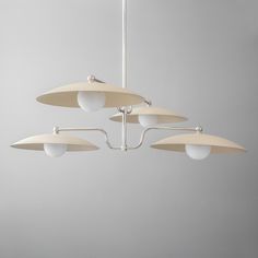 four lights hanging from a ceiling fixture in a room with gray walls and flooring