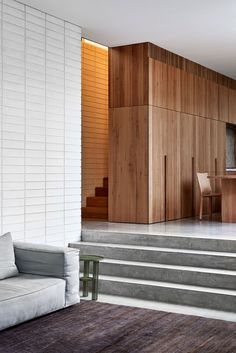 a living room filled with furniture next to a wooden wall covered in wood slats