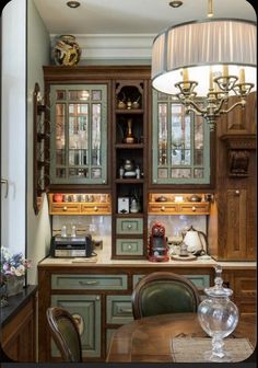 a dining room and kitchen area with green cabinets