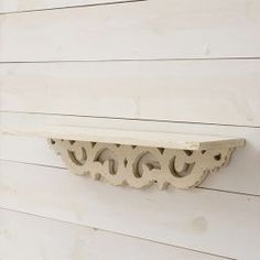 a white shelf on the side of a house