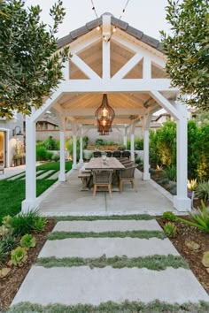 an outdoor dining area is shown in the evening hours with lights hanging from the roof