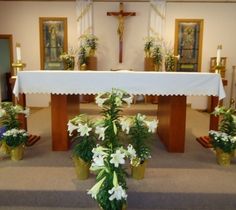 the altar is decorated with white flowers and greenery