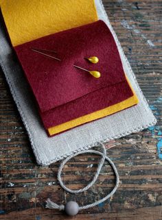 a close up of a piece of cloth on a table with some pins in it