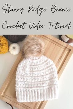 a white knitted hat sitting on top of a cutting board