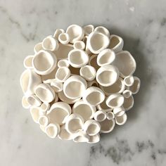 a pile of white bowls sitting on top of a marble counter