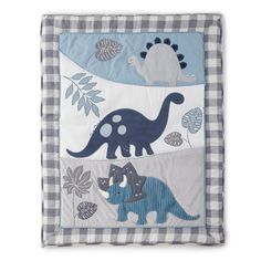 a blue and white checkered pillow with dinosaurs on the front, two dinos in the background