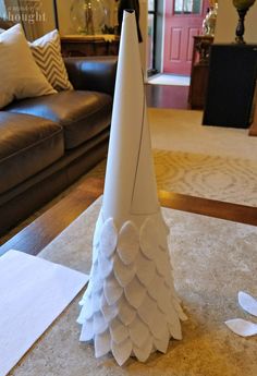 a white paper cone sitting on top of a table in front of a brown couch