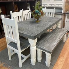 a wooden table with two white chairs and a bench