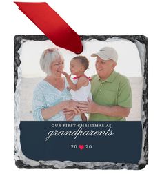 an ornament with the words our first christmas as grandparents on it and a red ribbon