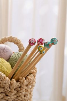 knitting needles and balls of yarn in a basket