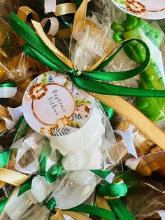 some candy wrapped in plastic and tied with green ribbon on top of other candies