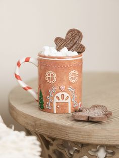 a cup filled with marshmallows and cookies on top of a wooden table