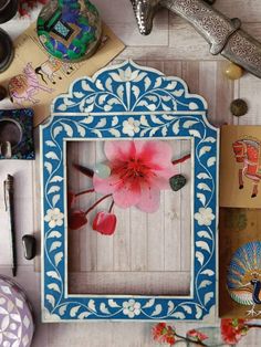 a blue and white frame sitting on top of a wooden table next to other items