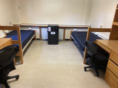 an empty room with two beds and desks