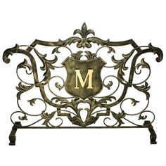 an ornate metal sign with the letter m on it's front and back sides