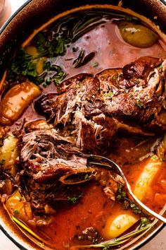 a pot filled with meat and vegetables on top of a table