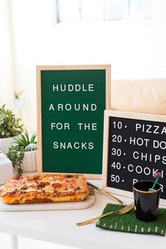 a table topped with pizza next to a sign