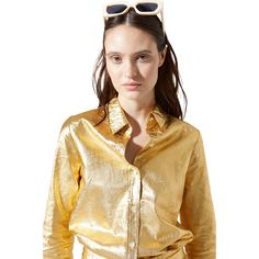 a woman wearing sunglasses and a gold shirt