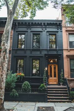 a black house with stairs leading up to the front door and windows on each side