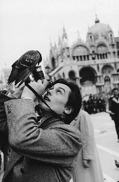 a man holding a bird on his arm in front of an ornately decorated building