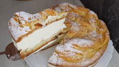 a white plate topped with a cake covered in powdered sugar and sliced into slices