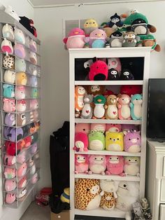 a white shelf filled with lots of stuffed animals