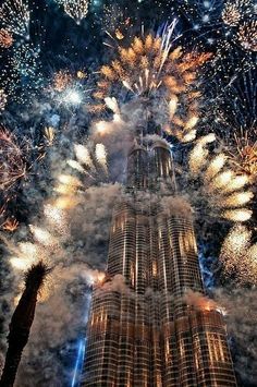 fireworks are lit up the sky above a tall building