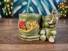 an elephant figurine sitting next to a coffee cup