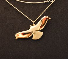 a necklace with a bird on it and a chain attached to the back of it