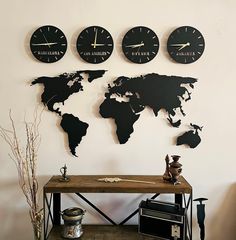 three clocks mounted to the wall above a table