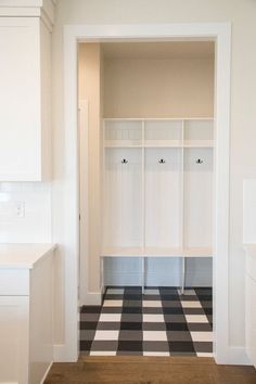 an empty white room with black and white checkerboard flooring on the floor