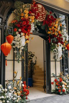 an entrance to a building decorated with flowers and lanterns