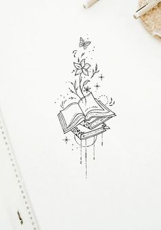 an open book sitting on top of a white table next to a pen and scissors