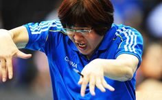 a man in blue shirt holding a tennis racquet on top of a court