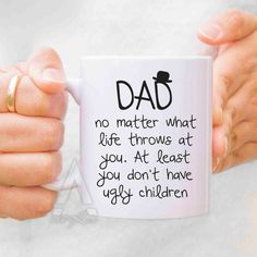 a person holding a coffee mug with the words dad on it in front of them