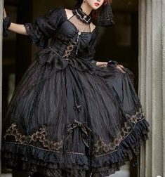 This Black Gothic Lolita Lace Wedding Dress With Corset Plus Size is a stunning alternative to a traditional white wedding dress. This dramatic and unique dress features a full-length black lace overlay with a corseted bodice and sweetheart neckline. The bodice is adorned with intricate silver embroidery, giving it a luxurious feel. The full-length skirt has a slight train and is finished off with a bow detail at the waist. The corset back allows for an adjustable fit to ensure you are comfortab Black Lace Corset Dress For Halloween, Black Corset Dress With Cancan For Costume Party, Elegant Black Corset Dress With Lace Patchwork, Black Gothic Ball Gown Dress, Gothic Black Corset Dress With Attached Cancan, Black Victorian Ball Gown For Evening, Black Fitted Corset Dress With Lace Sleeves, Black Gothic Victorian Ball Gown, Black Victorian Ball Gown For Costume Party