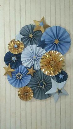 several blue and gold paper stars hanging on the wall in front of a white door