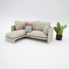 a crocheted couch next to a potted cactus