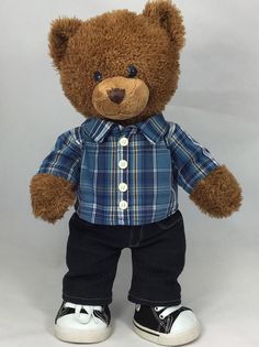 a brown teddy bear wearing a blue shirt and jeans