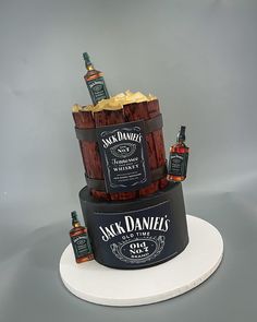 a three tiered cake with whiskey bottles on top