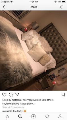 an instagram photo of a bed with white and grey pillows on top of it