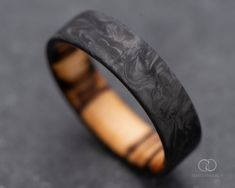 a wooden ring with black and brown wood inlay