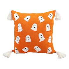 an orange pillow with white ghost faces on it