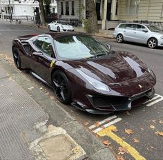 a maroon sports car is parked on the street