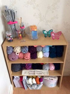 a shelf filled with yarn and knitting supplies