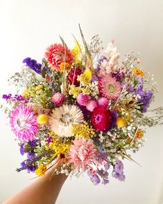 a person holding a bouquet of flowers in their hand