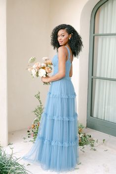 a woman in a blue dress holding a bouquet