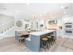 a large kitchen with an island in the middle and lots of stools around it