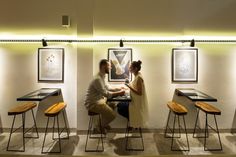 a man and woman sitting at a table in an art gallery