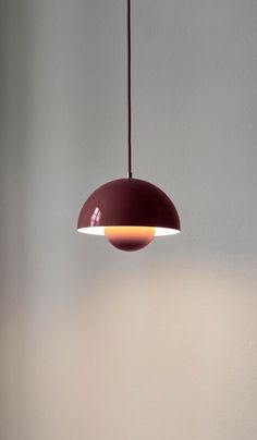 a red light hanging from a ceiling in a room with white walls and flooring